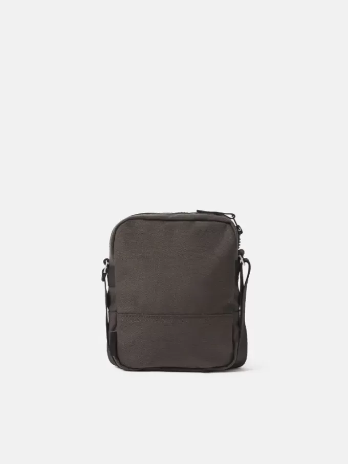 Sac pochette avec multiples poches et fermeture à glissière sur le dessus.